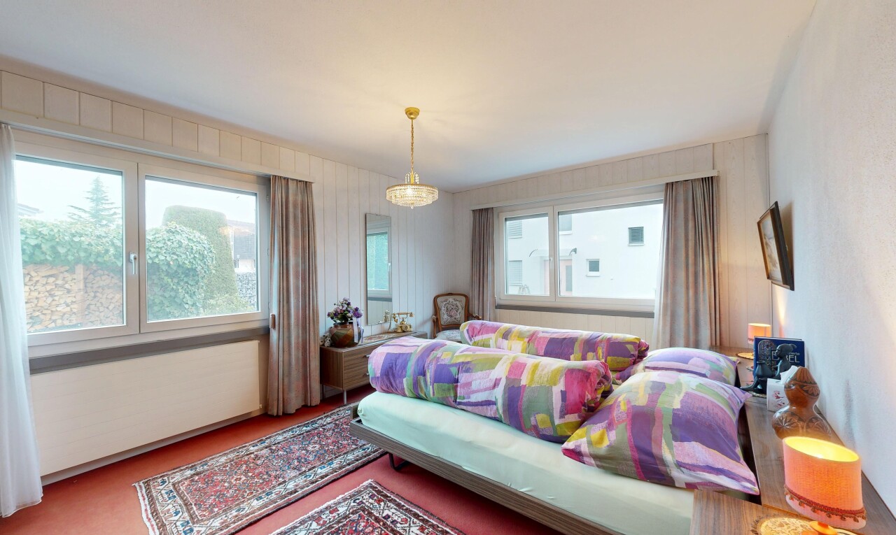 room featuring multiple windows, carpet flooring, and a chandelier