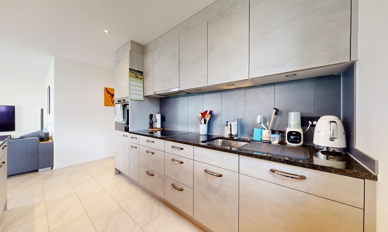 cuisine avec inside property, plans de travail en pierre, drywall, cloison sèche, et évier