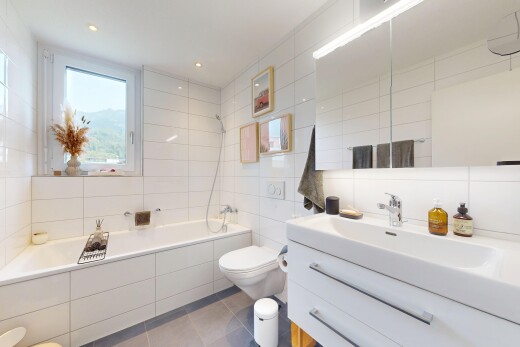 bathroom with tile walls, vanity, tiled shower / bath combo, and light tile patterned flooring