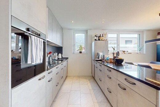 kitchen featuring oven, light tile patterned flooring, and dark stone countertops