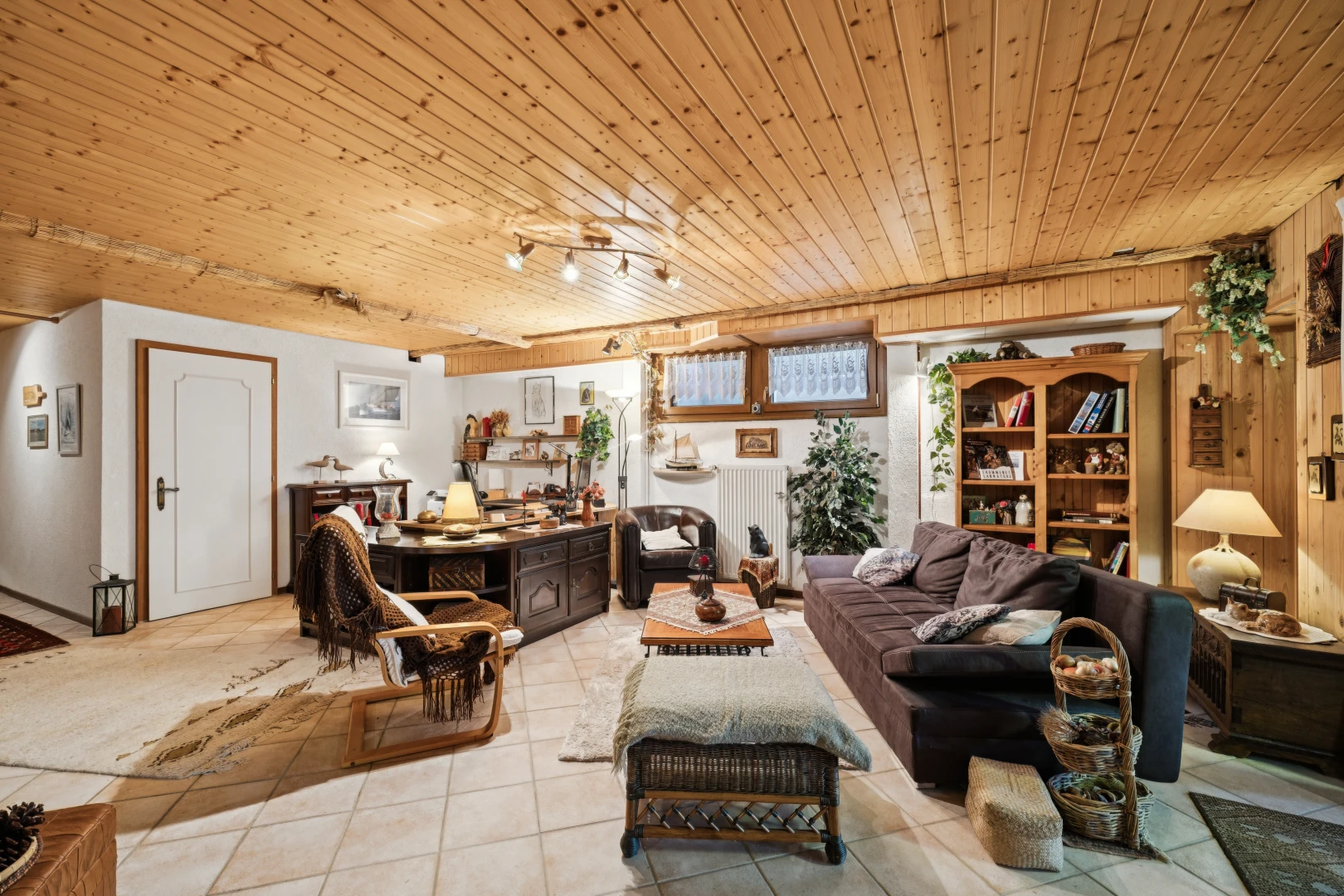 salon avec éclairage sur rail, plafond en bois, wood ceiling, inside property, et sol en carrelage