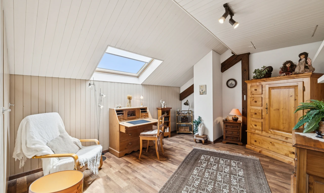 salon avec éclairage sur rail, vaulted ceiling, plafond voûté, puits de lumière, et wood finish floor