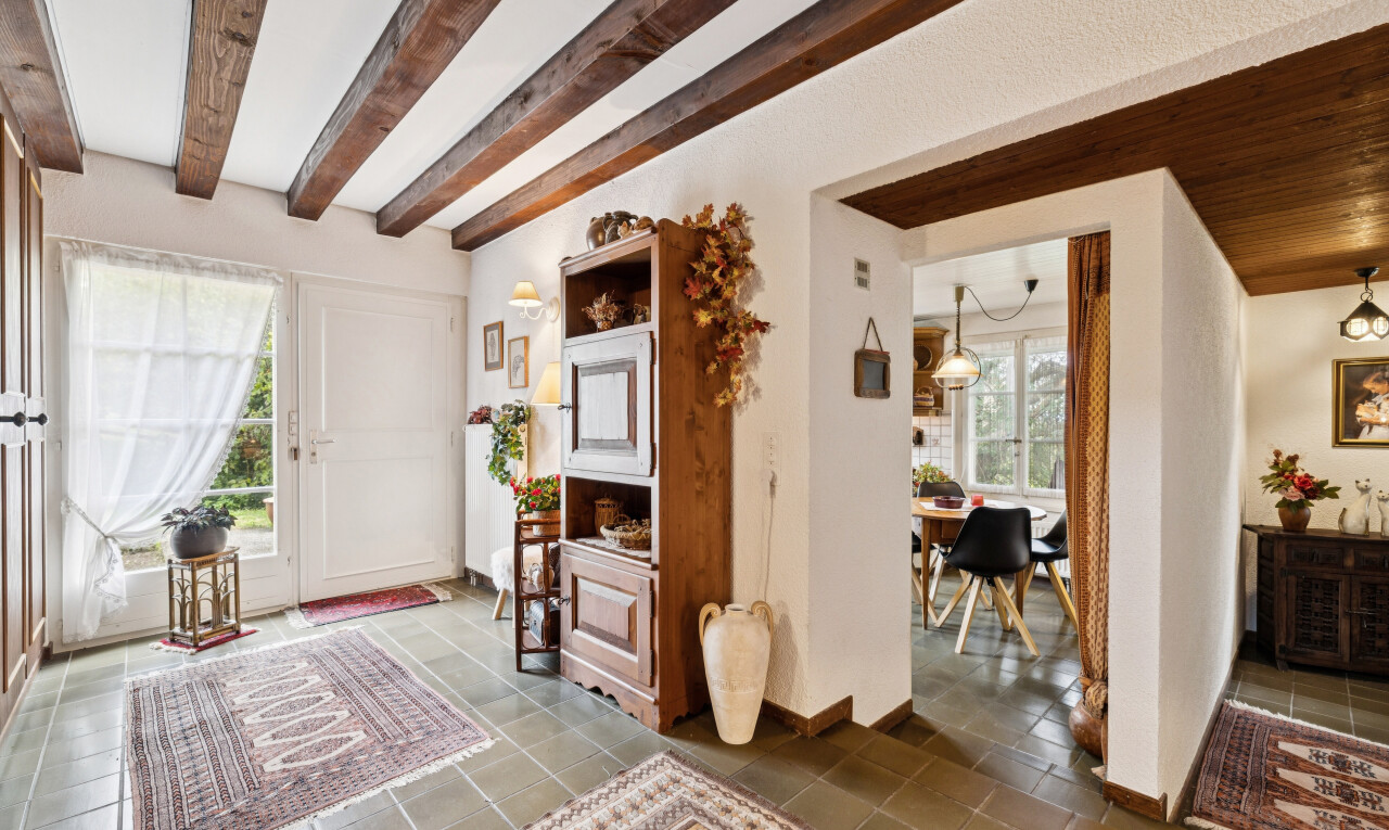 couloir avec high end ceiling, inside property, beamed ceiling, plafond à poutres, et lumière naturelle