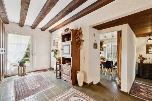 couloir avec high end ceiling, inside property, beamed ceiling, plafond à poutres, et lumière naturelle