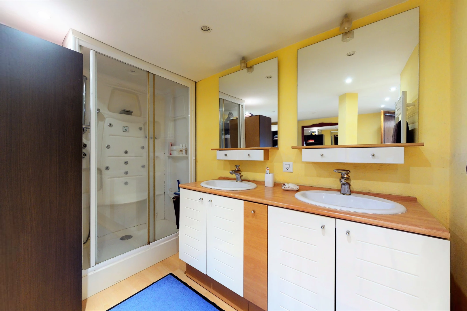 salle de bains avec meuble-lavabo, double vasque, miroir, et douche