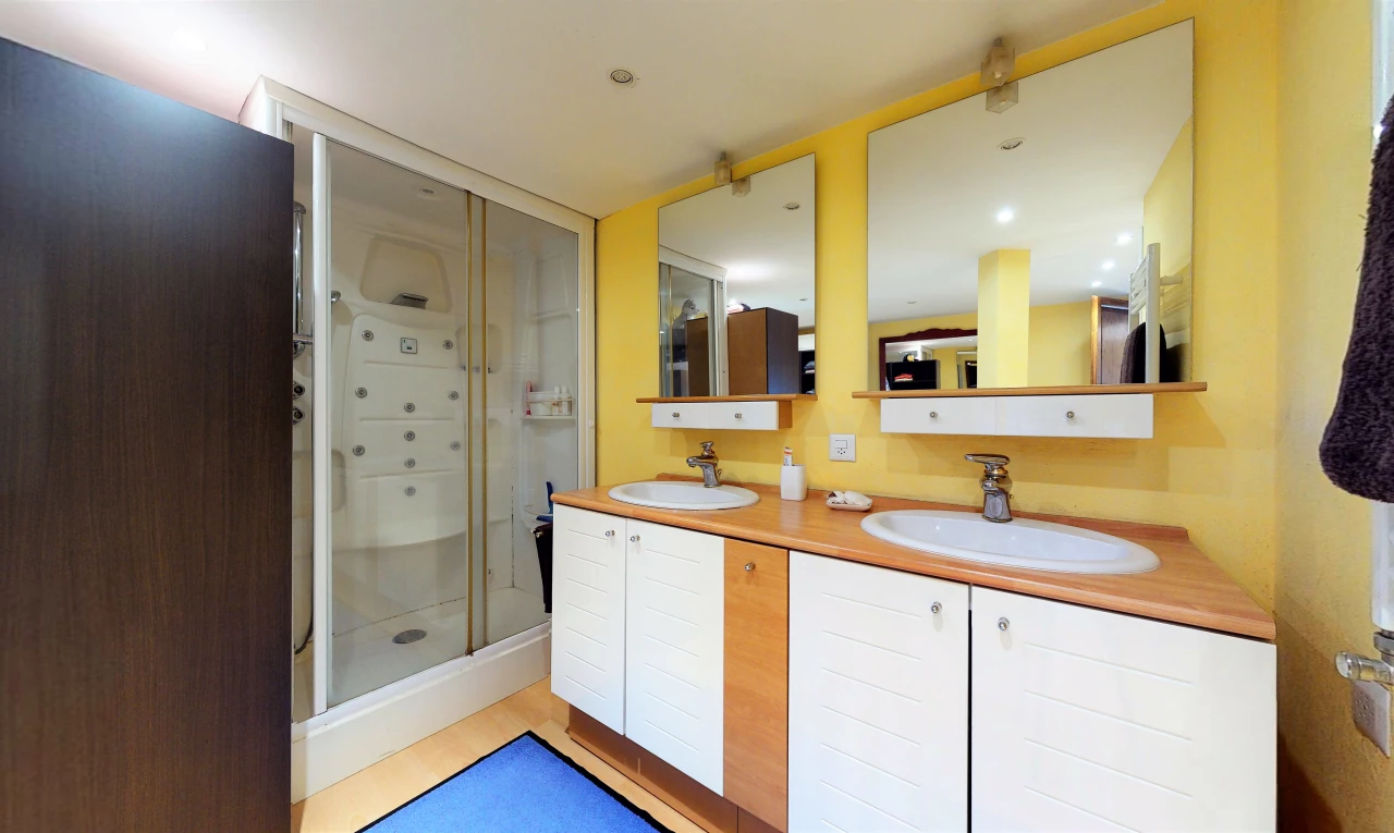 salle de bains avec meuble-lavabo, double vasque, miroir, et douche