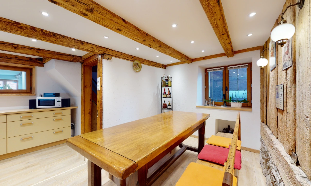 salle à manger avec poutres apparentes, lumière naturelle, et micro-onde