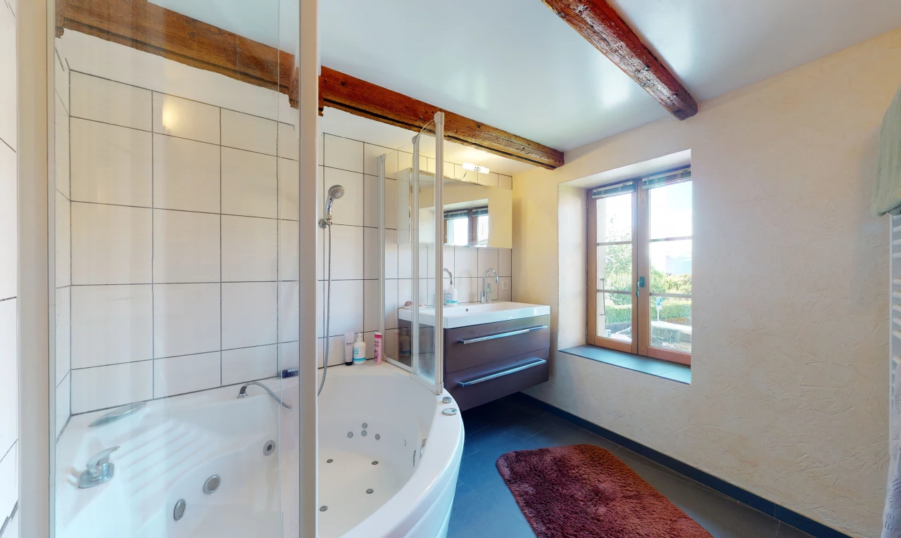 salle de bains avec lumière naturelle, baignoire, et meuble-lavabo