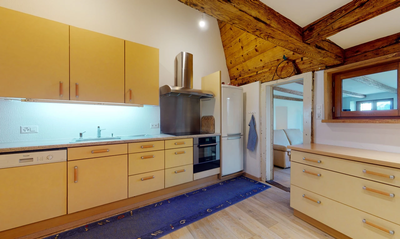 cuisine avec parquet, réfrigérateur, hotte, cuisinière électrique, four, lave-vaisselle, armoires marrons, et comptoirs claires