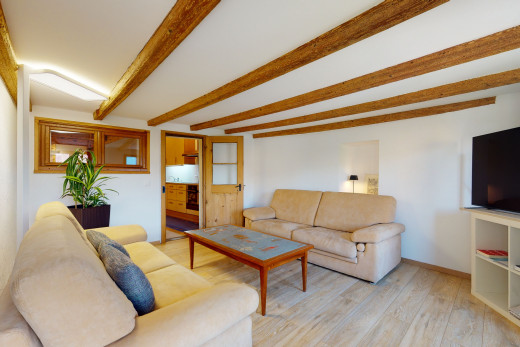 hartholzboden wohnzimmer mit balkendecke und fernseher