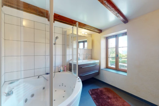 salle de bains avec lumière naturelle, baignoire, et meuble-lavabo