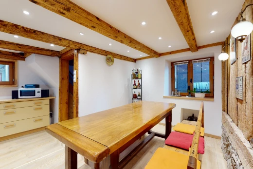 salle à manger avec poutres apparentes, lumière naturelle, et micro-onde