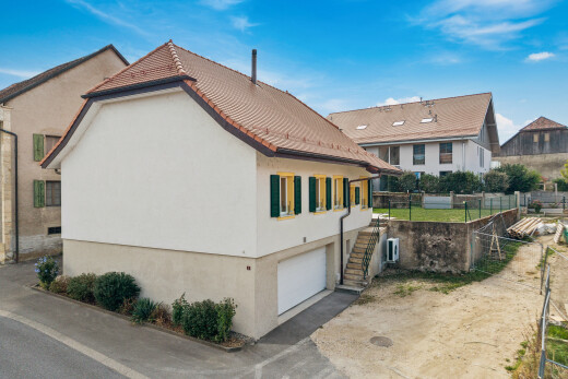 façade avec bardage en stuc, clôture, garage intégré, property visible, et day time