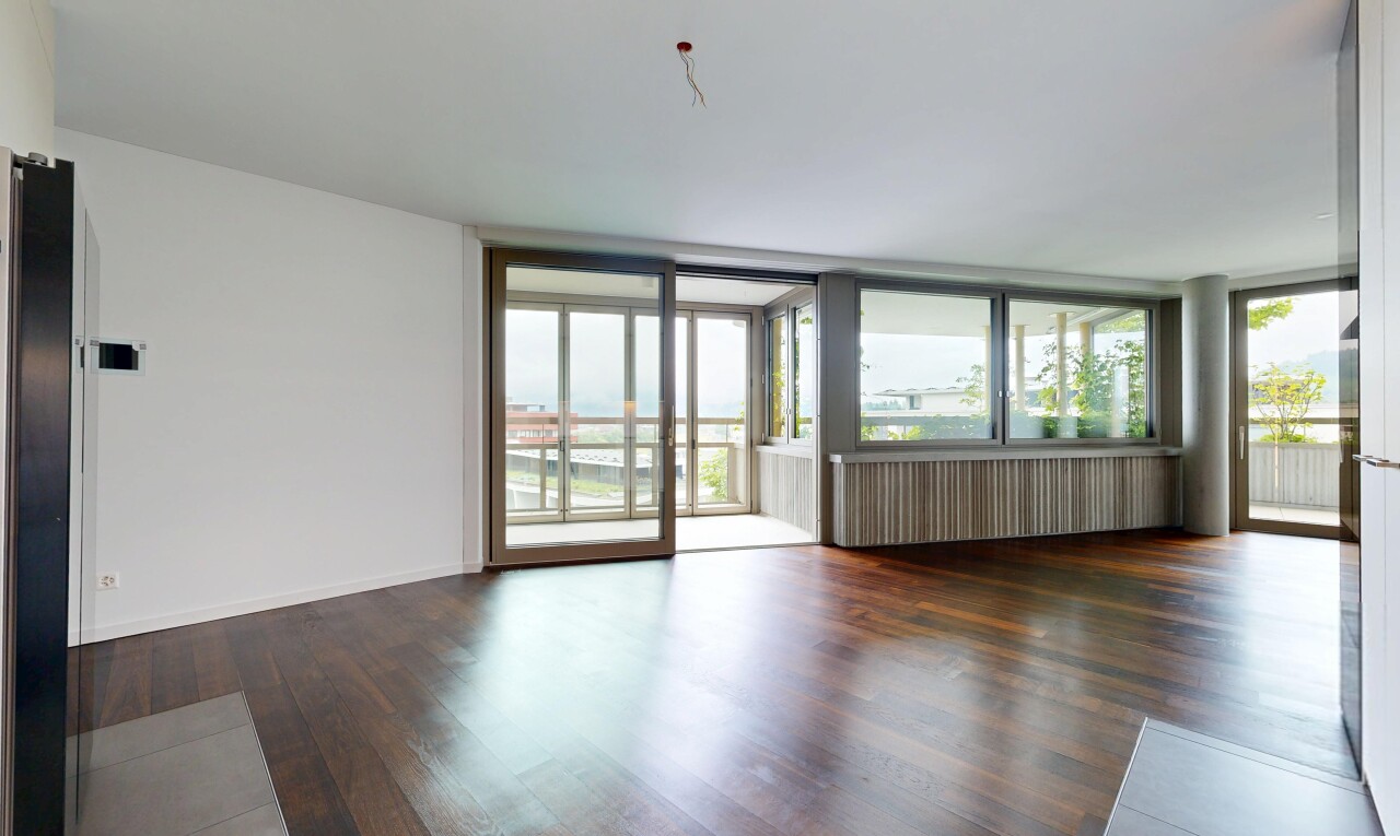 pièce vide avec wood finish floor, sol en finition bois, drywall, cloison sèche, et natural light