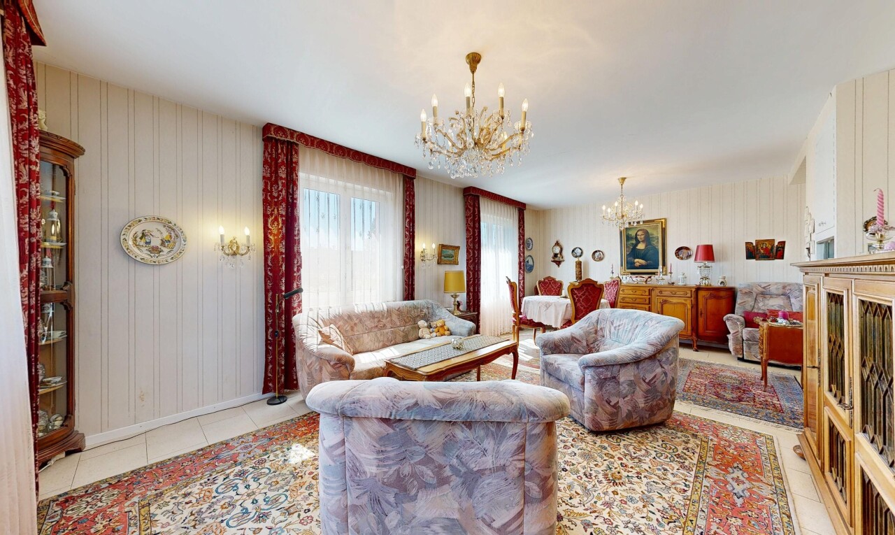 living room featuring a chandelier, light tile patterned floors, and wallpapered walls