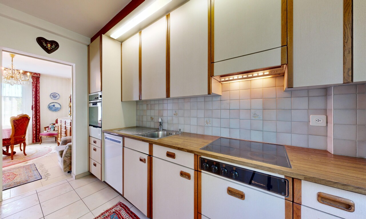 two tone kitchen with tasteful backsplash, light tile patterned floors, black electric cooktop, dishwasher, and two tone cabinetry