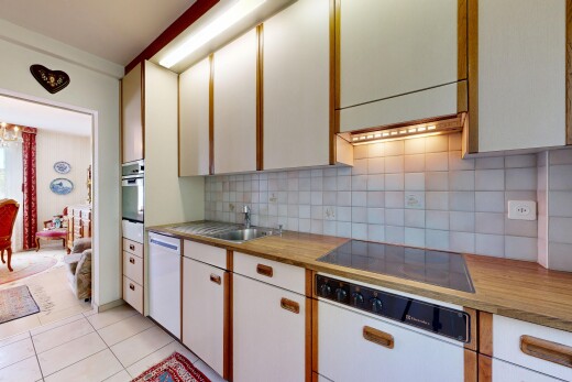 cuisine avec light countertops, backsplash, dosseret, light floor, et inside property
