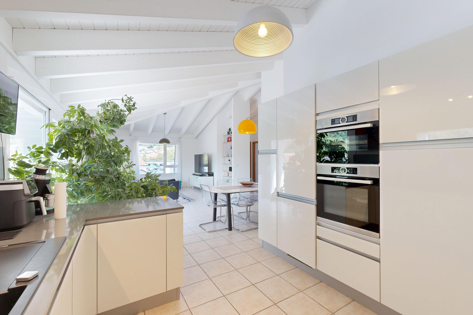 cuisine avec beamed ceiling, éclairage suspendu, high end ceiling, four double, et light floor
