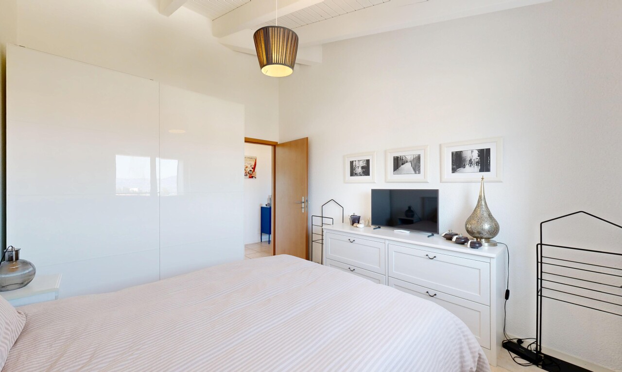 chambre avec plafond à poutres, beamed ceiling, high end ceiling, télévision, et cloison sèche