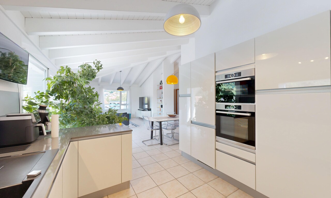cuisine avec beamed ceiling, éclairage suspendu, high end ceiling, four double, et light floor