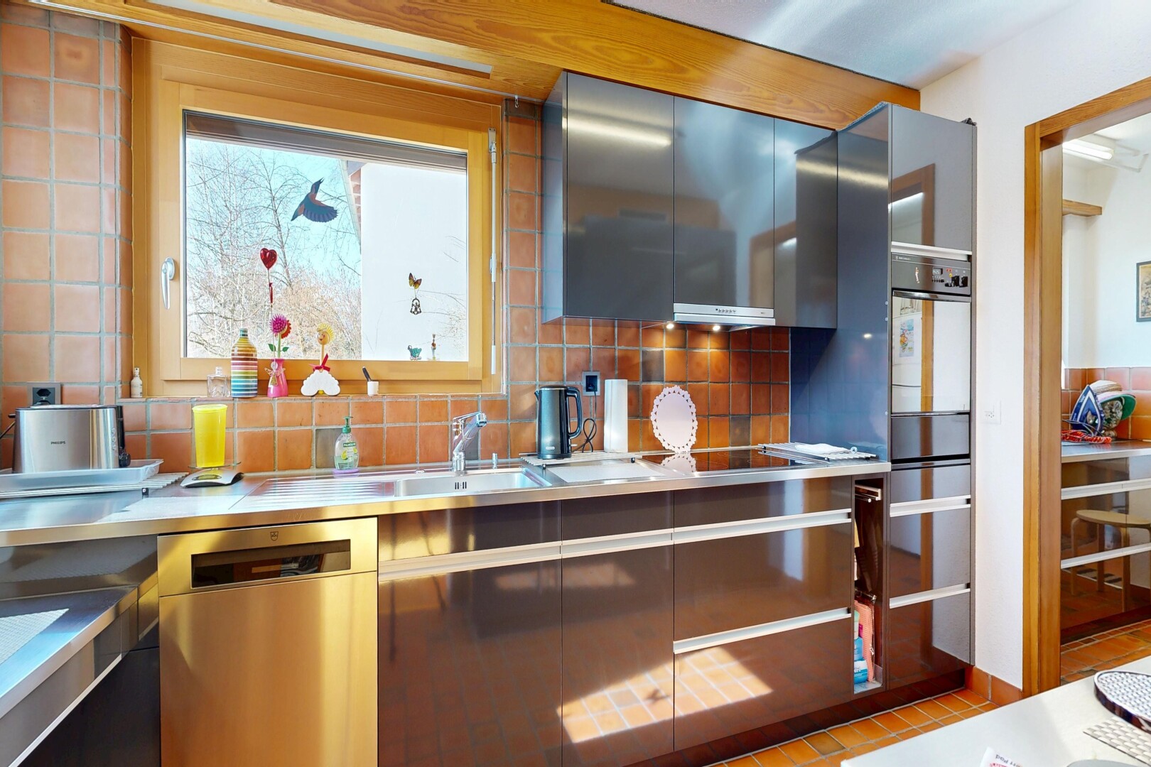cuisine avec lave-vaisselle, dosseret, backsplash, inside property, et light countertops