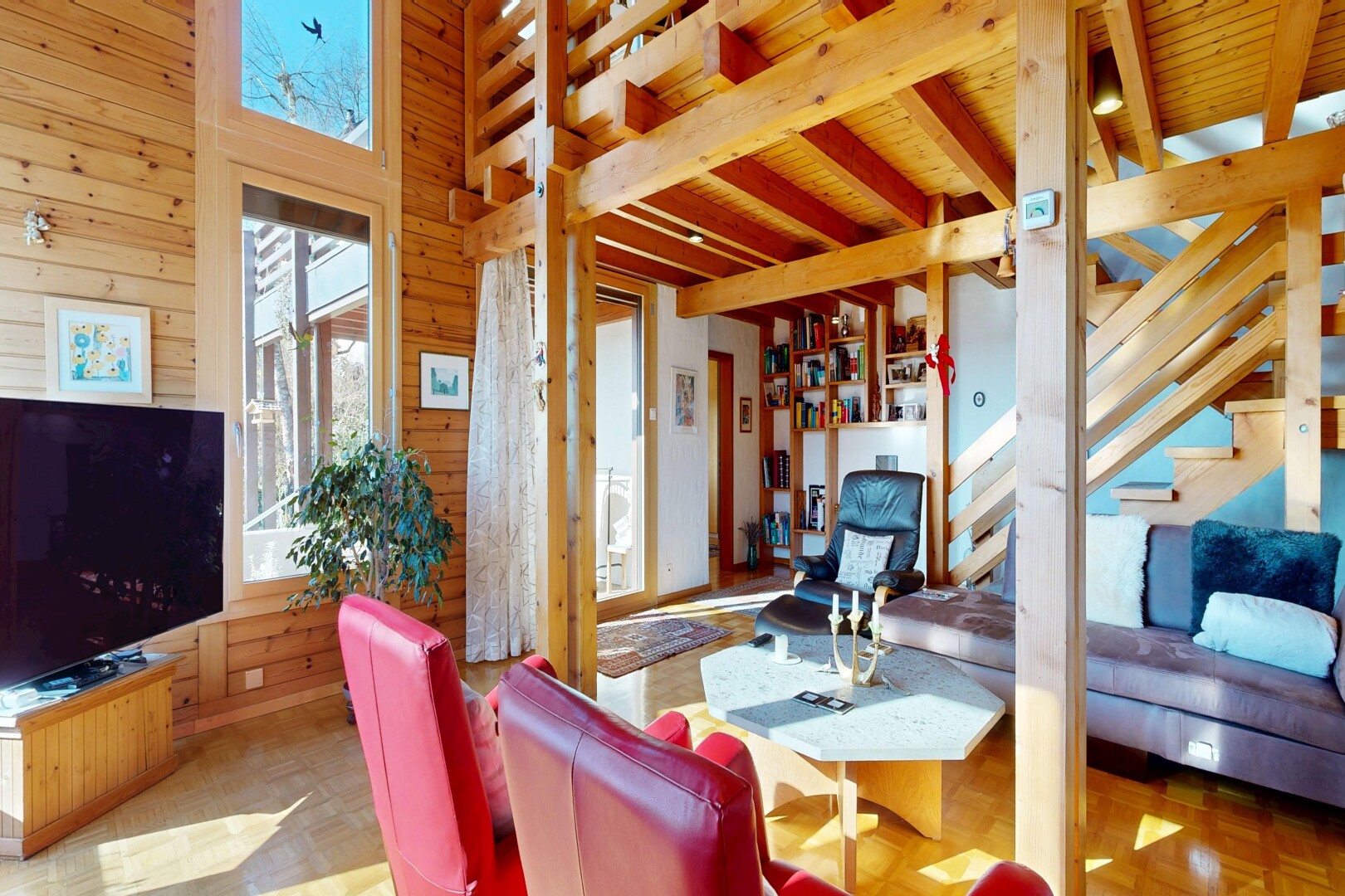 salon avec télévision, natural light, lumière naturelle, wood wall, et mur en bois