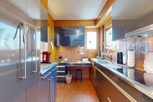 kitchen with high end fridge, decorative backsplash, black electric cooktop, light tile patterned floors, and stainless steel counters