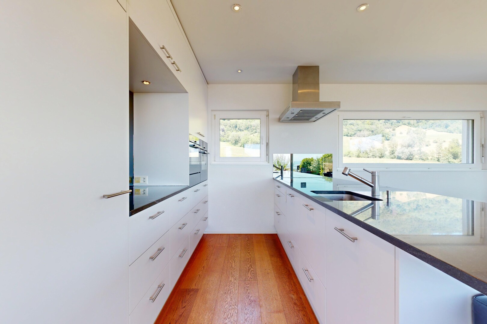 küche mit weiße schränke, white cabinets, holzfußboden, wood finish floor, und dunstabzugshaube