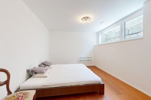 zimmer / schlafzimmer mit natural light, natürliches licht, inside property, wood finish floor, und holzfußboden