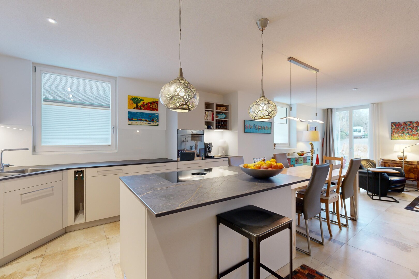 küche mit arbeitsplatten, weiße schränke, natürliches licht, pendelleuchte, und kücheninsel