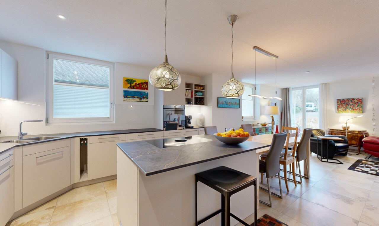 küche mit arbeitsplatten, weiße schränke, natürliches licht, pendelleuchte, und kücheninsel