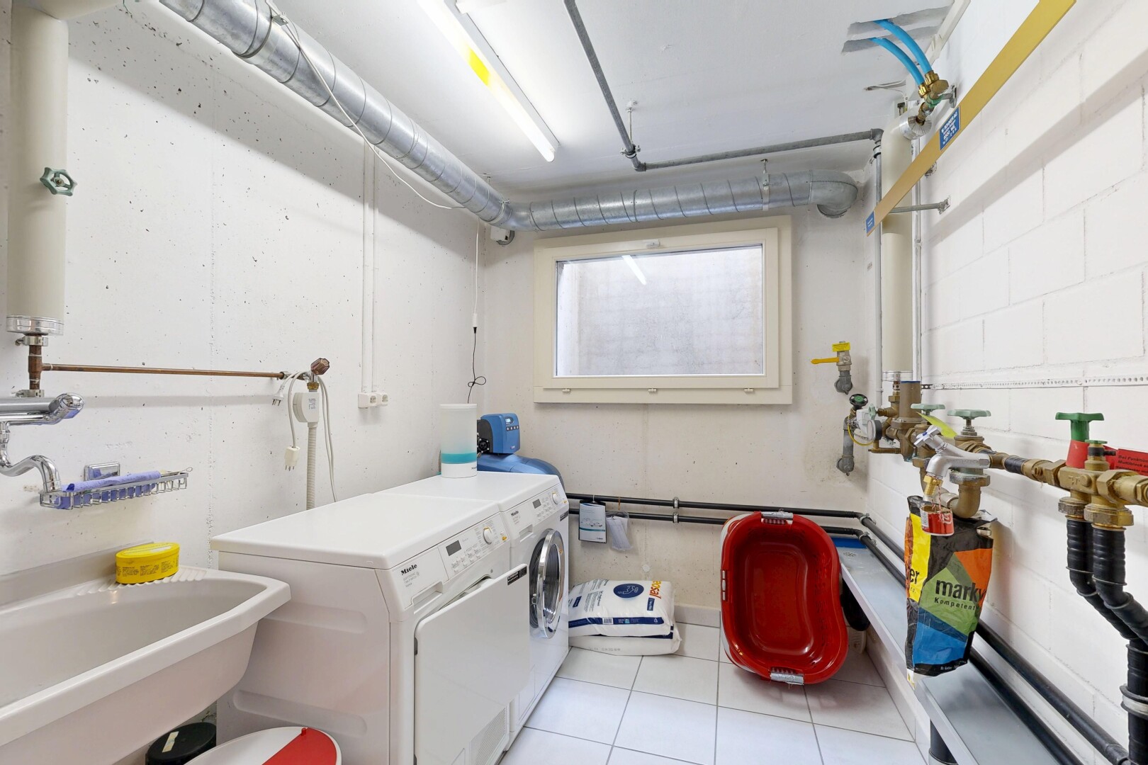 wäschekammer mit waschbecken, wäscherei, inside community, drywall, und light floor