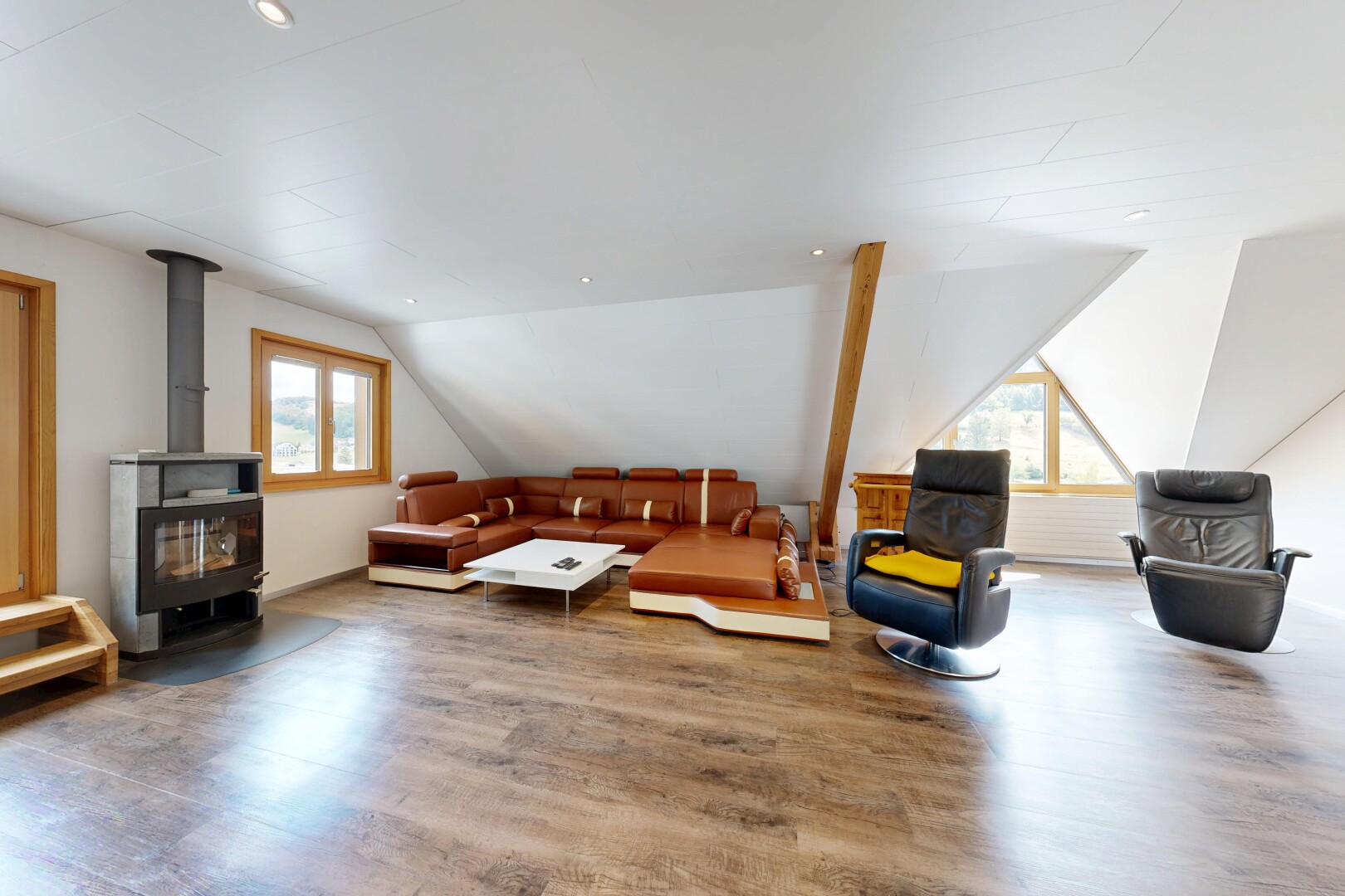 salon avec poêle à bois, wood finish floor, sol en finition bois, éclairage encastré, et drywall