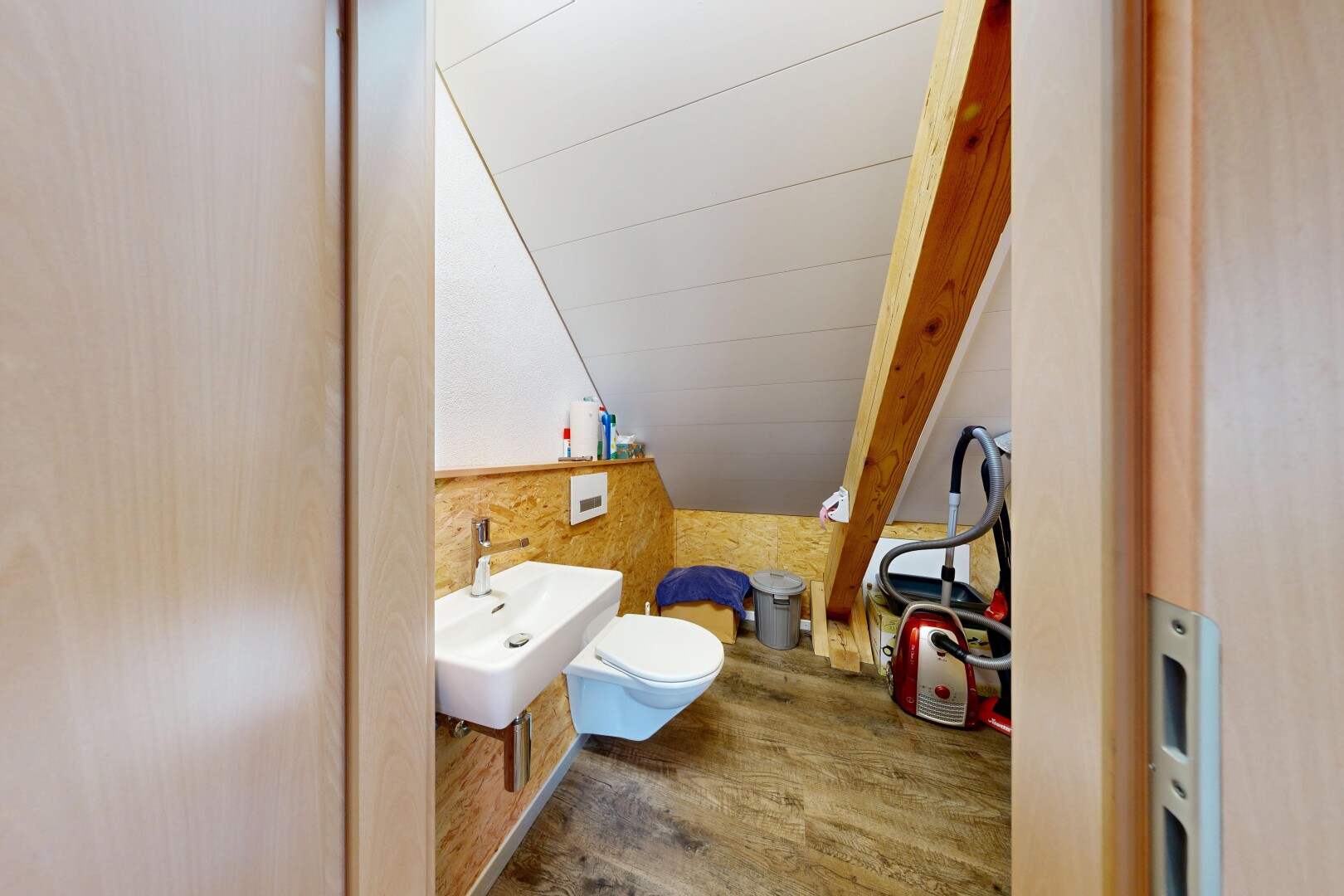 salle de bains avec wood finish floor, sol en finition bois, toilette, évier, et inside property