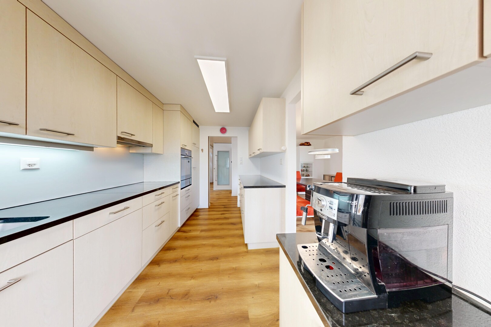 cuisine avec wood finish floor, sol en finition bois, light floor, dark countertops, et plans de travail