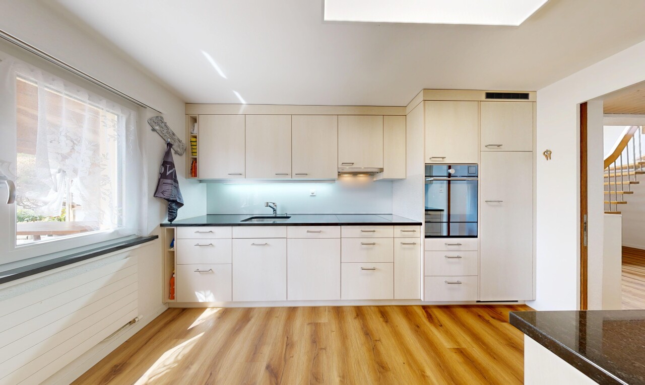 cuisine avec dark countertops, four, sol en finition bois, wood finish floor, et light floor