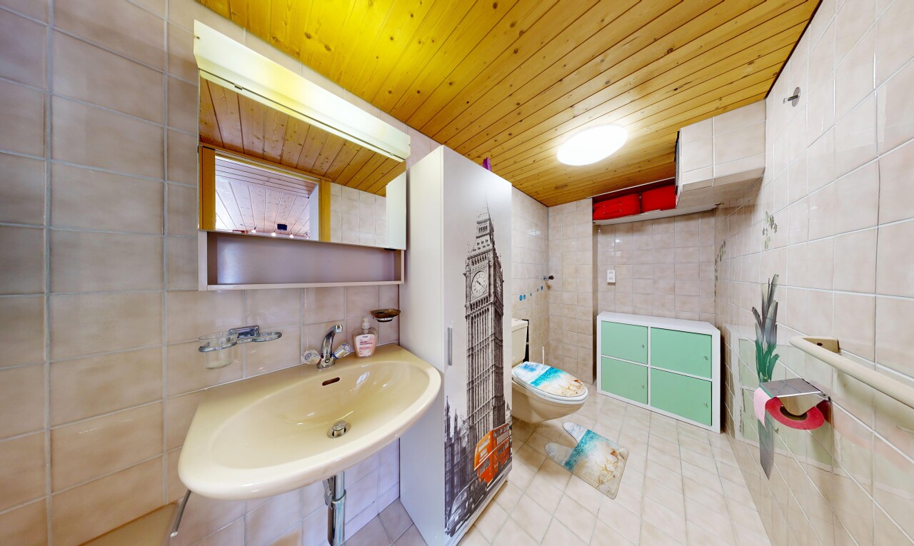 salle de bains avec tile wall, mur en carrelage, wood ceiling, plafond en bois, et toilette