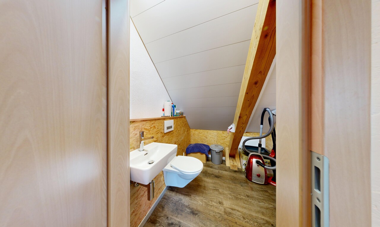 salle de bains avec wood finish floor, sol en finition bois, toilette, évier, et inside property