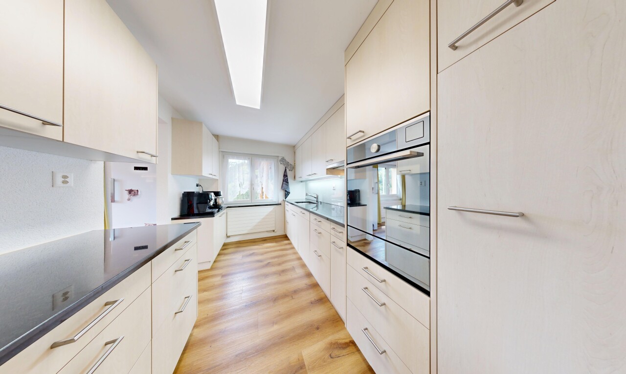 cuisine avec light floor, sol en finition bois, wood finish floor, four, et dark countertops