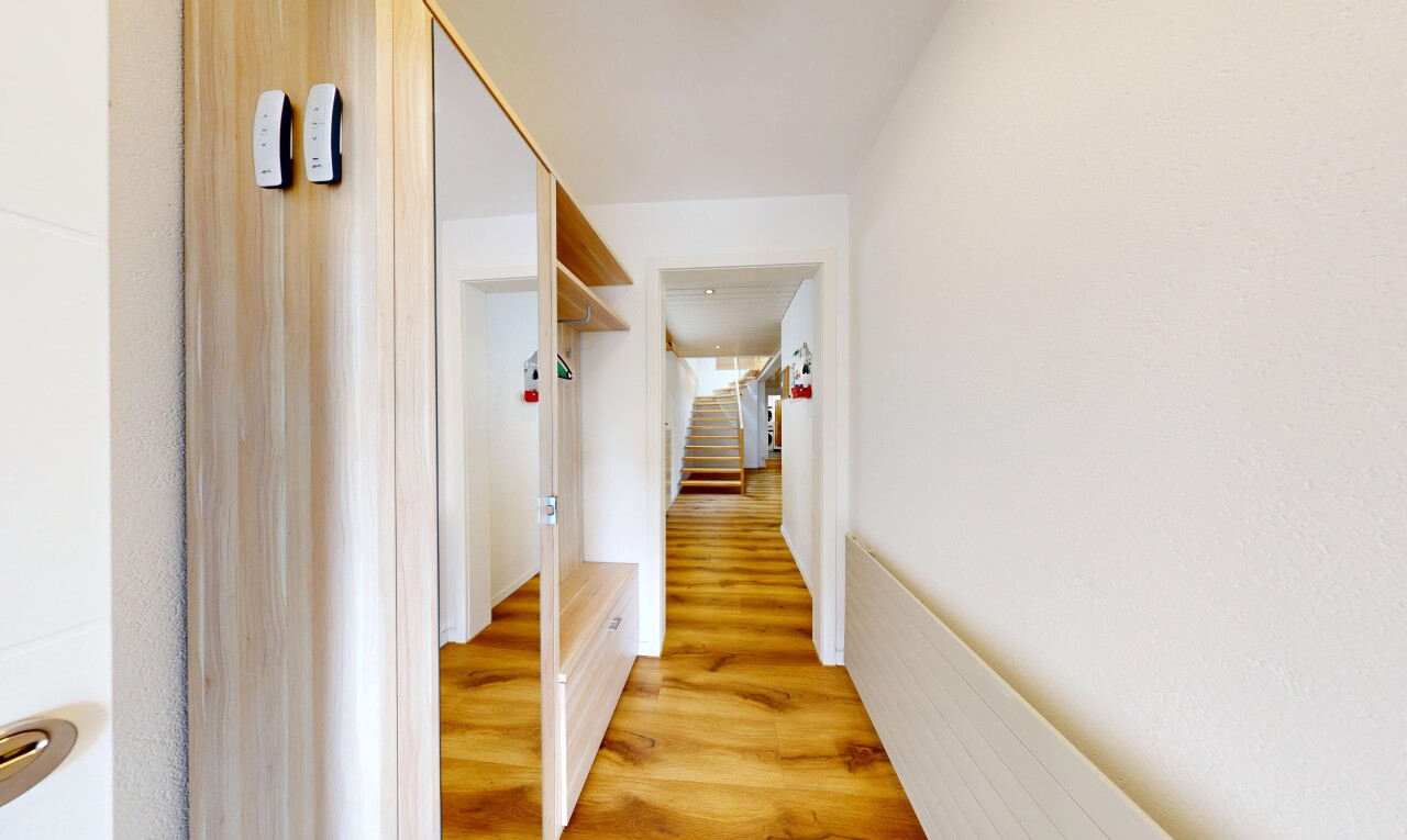 couloir avec wood finish floor, sol en finition bois, escaliers, et inside property