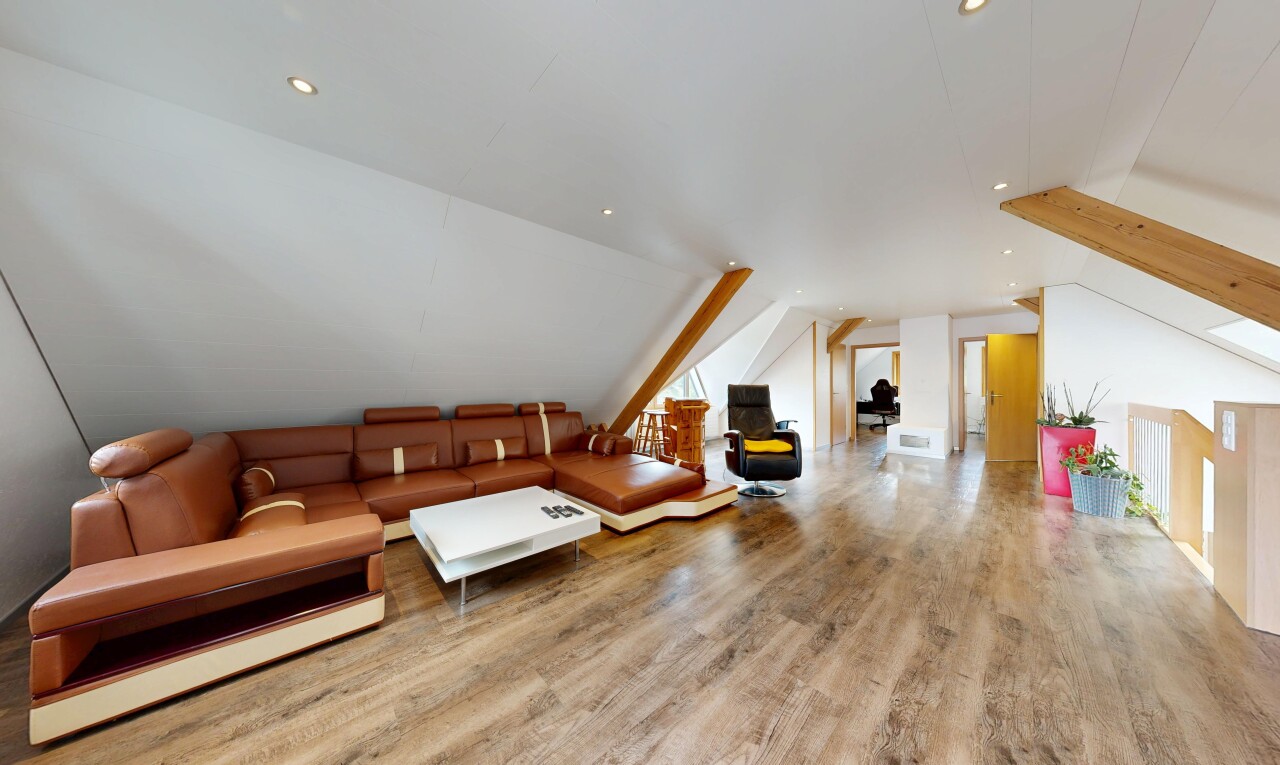 salon avec sol en finition bois, wood finish floor, éclairage encastré, pièce supplémentaire, et plafond voûté