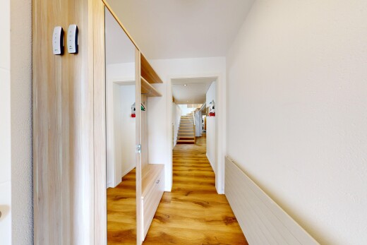 couloir avec wood finish floor, sol en finition bois, escaliers, et inside property