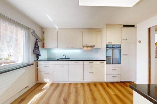 cuisine avec dark countertops, four, sol en finition bois, wood finish floor, et light floor
