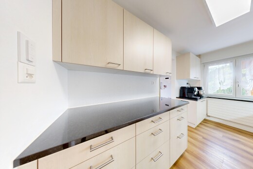 cuisine avec dark countertops, plans de travail, light floor, wood finish floor, et sol en finition bois