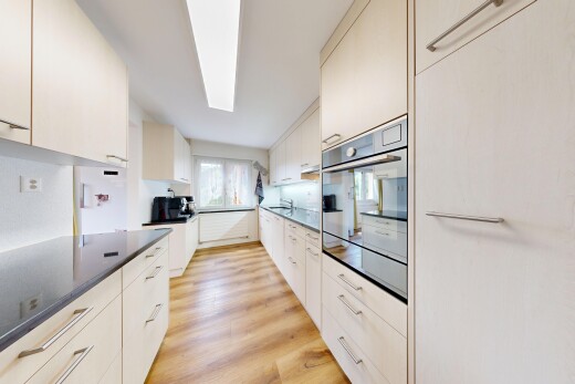 cuisine avec light floor, sol en finition bois, wood finish floor, four, et dark countertops