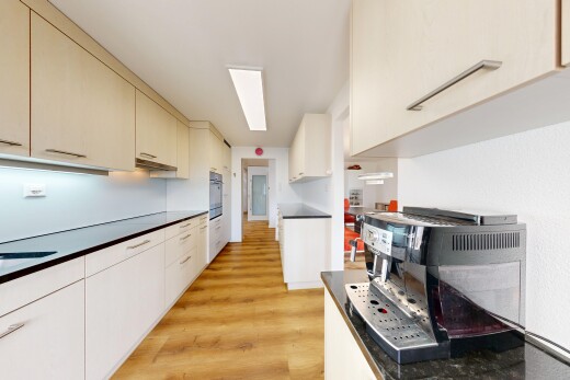 cuisine avec wood finish floor, sol en finition bois, light floor, dark countertops, et plans de travail
