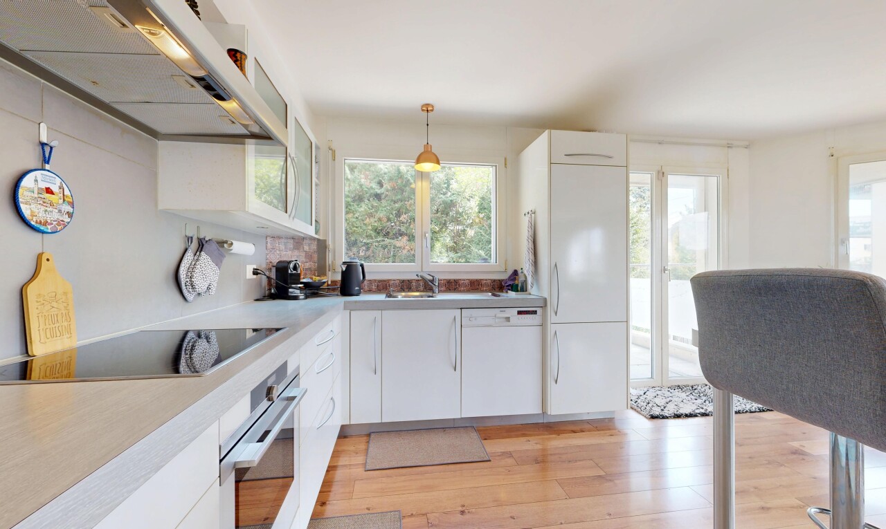 cuisine avec hotte, white cabinets, armoires blanches, four, et sol en finition bois