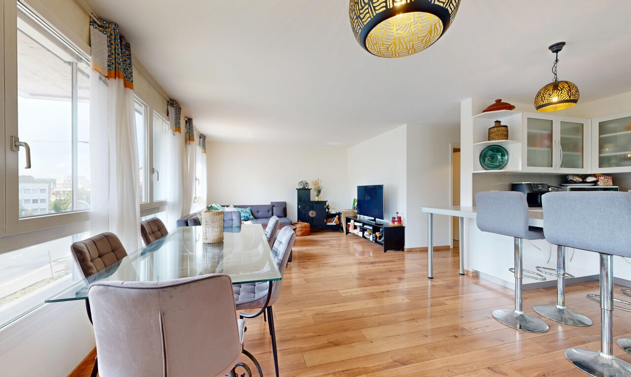 salon / salle à manger avec éclairage suspendu, wood finish floor, sol en finition bois, drywall, et cloison sèche
