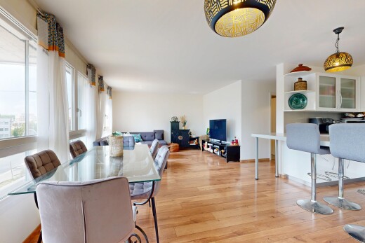 salon / salle à manger avec éclairage suspendu, wood finish floor, sol en finition bois, drywall, et cloison sèche