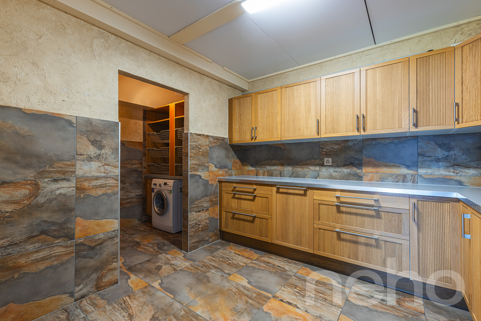 cuisine avec armoires de style shaker, inside property, sol en finition pierre, stone finish floor, et lave-linge et sèche-linge